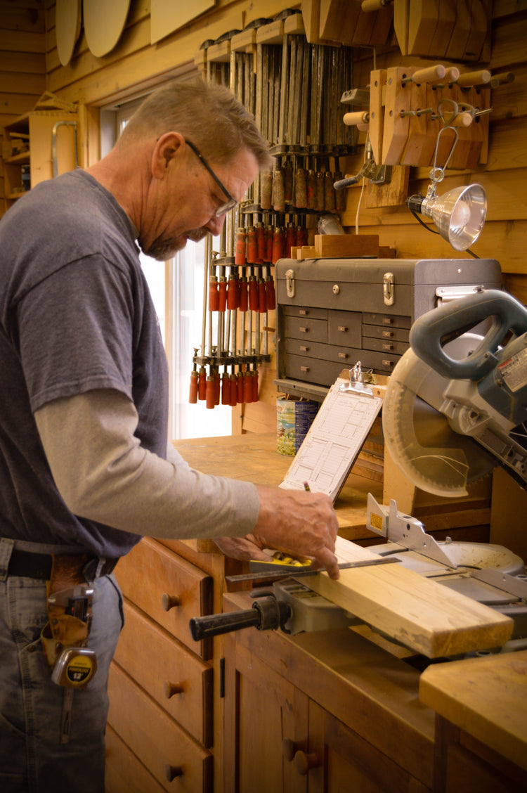 Tom marking a board at his workbench